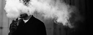 Young person in a cloud of smoke due to vaping