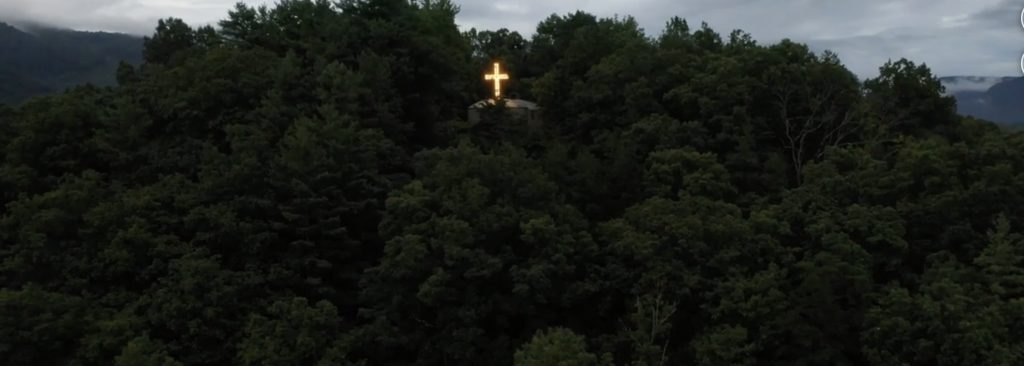 An illuminated Christian cross on a hillside in Virginia
