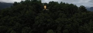 An illuminated Christian cross on a hillside in Virginia