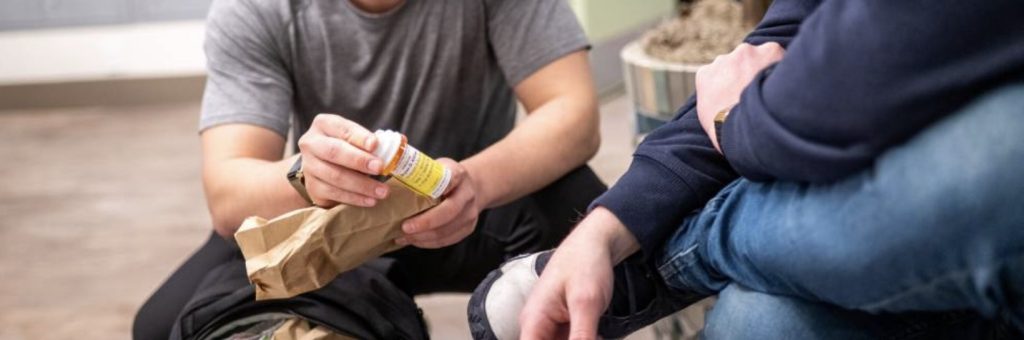 Medical professional handing a prescription drug container to someone