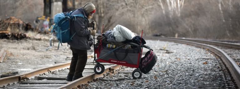 Homeless person in Bangor, Maine moving away from an encampment that was dismantled