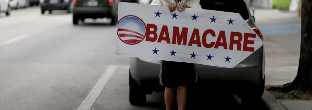 image of person holding promotional Obamacare poster