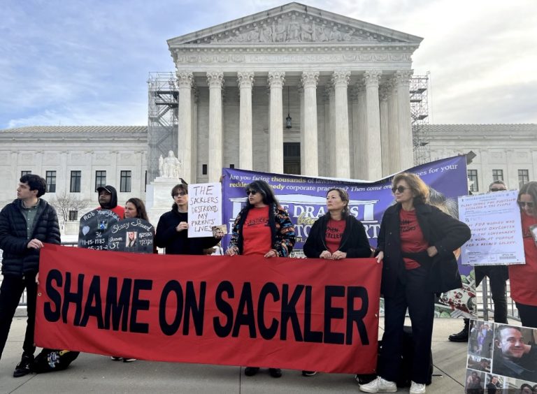 Sackler family protestors hollding a banner