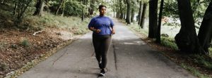 Overweight woman walking through a park for exercise