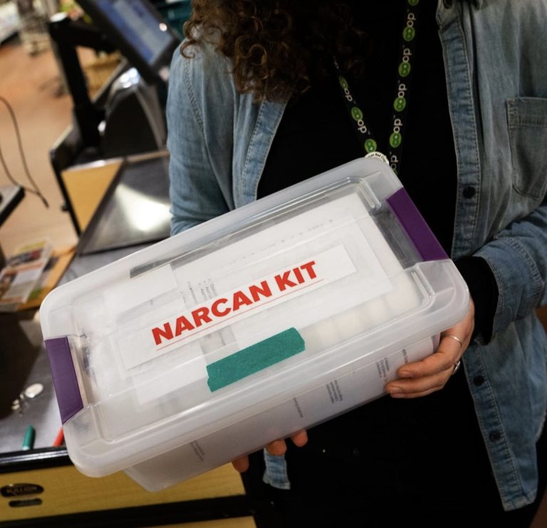 Woman holding a Narcan Kit